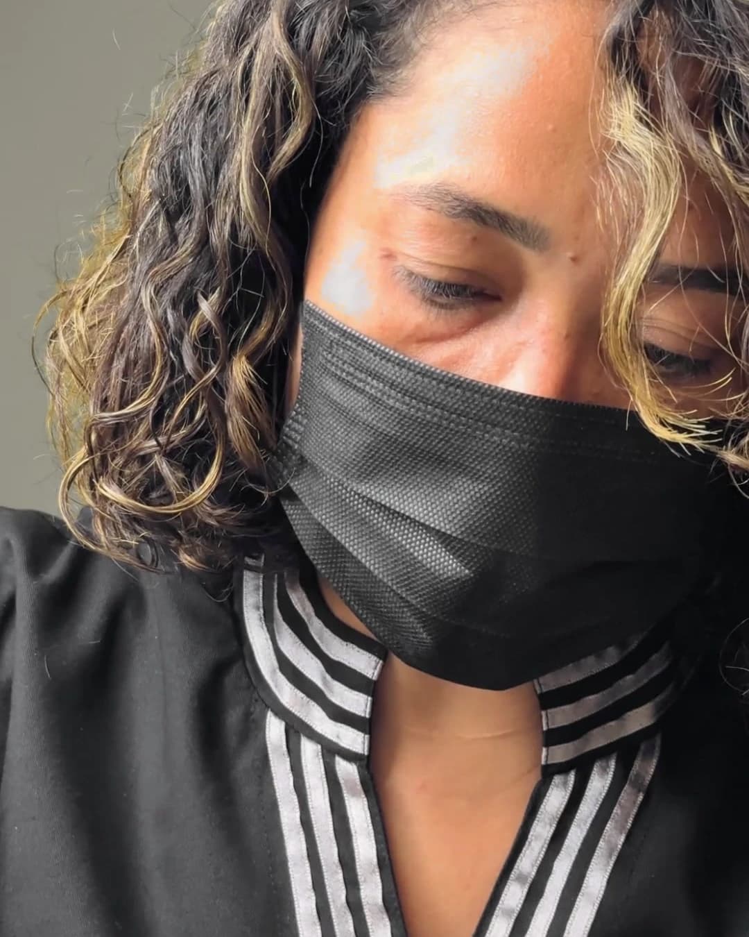 Francielly Costa applying the technique, in a gown and mask.