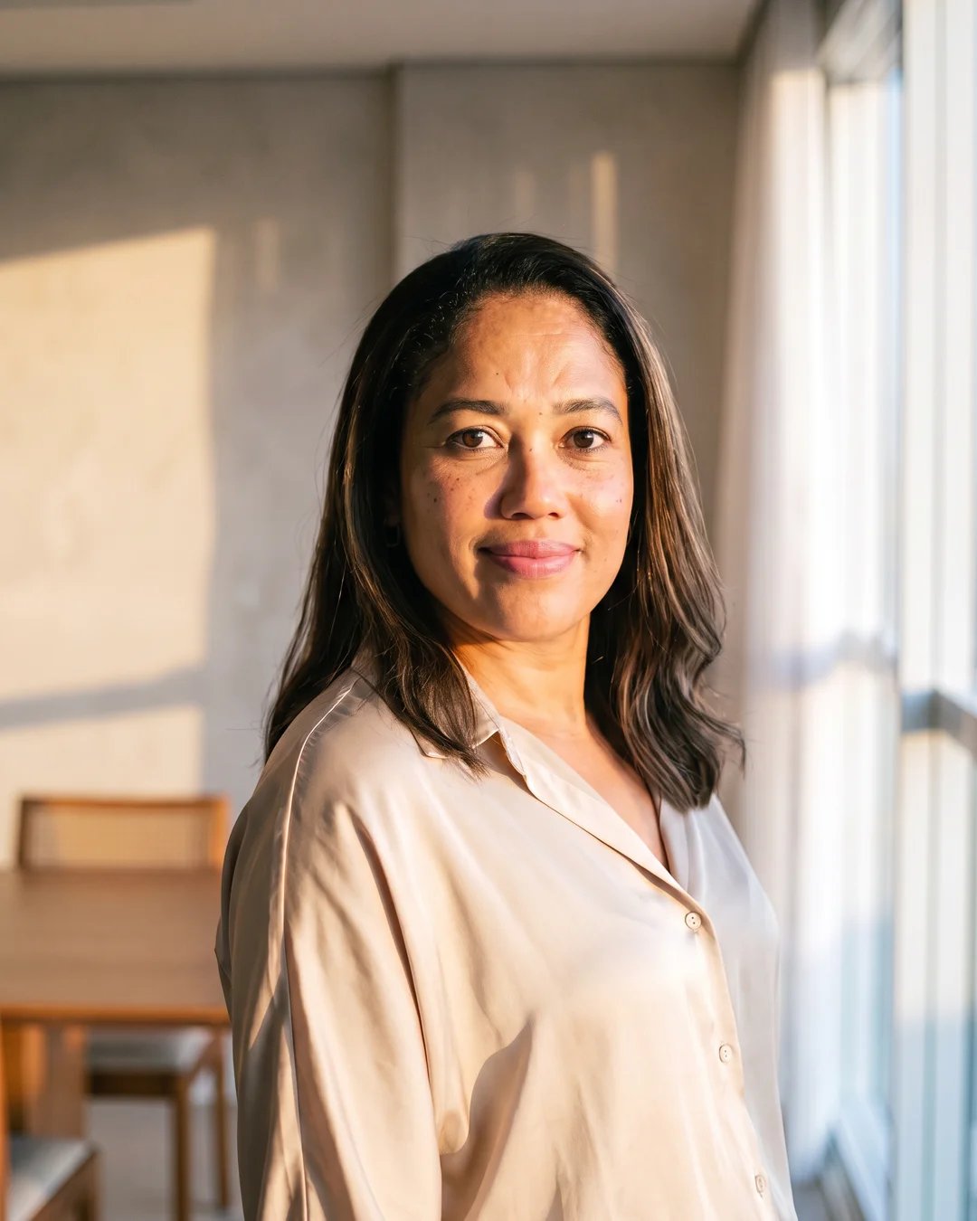 A portrait of Francielly Costa, beside a window.