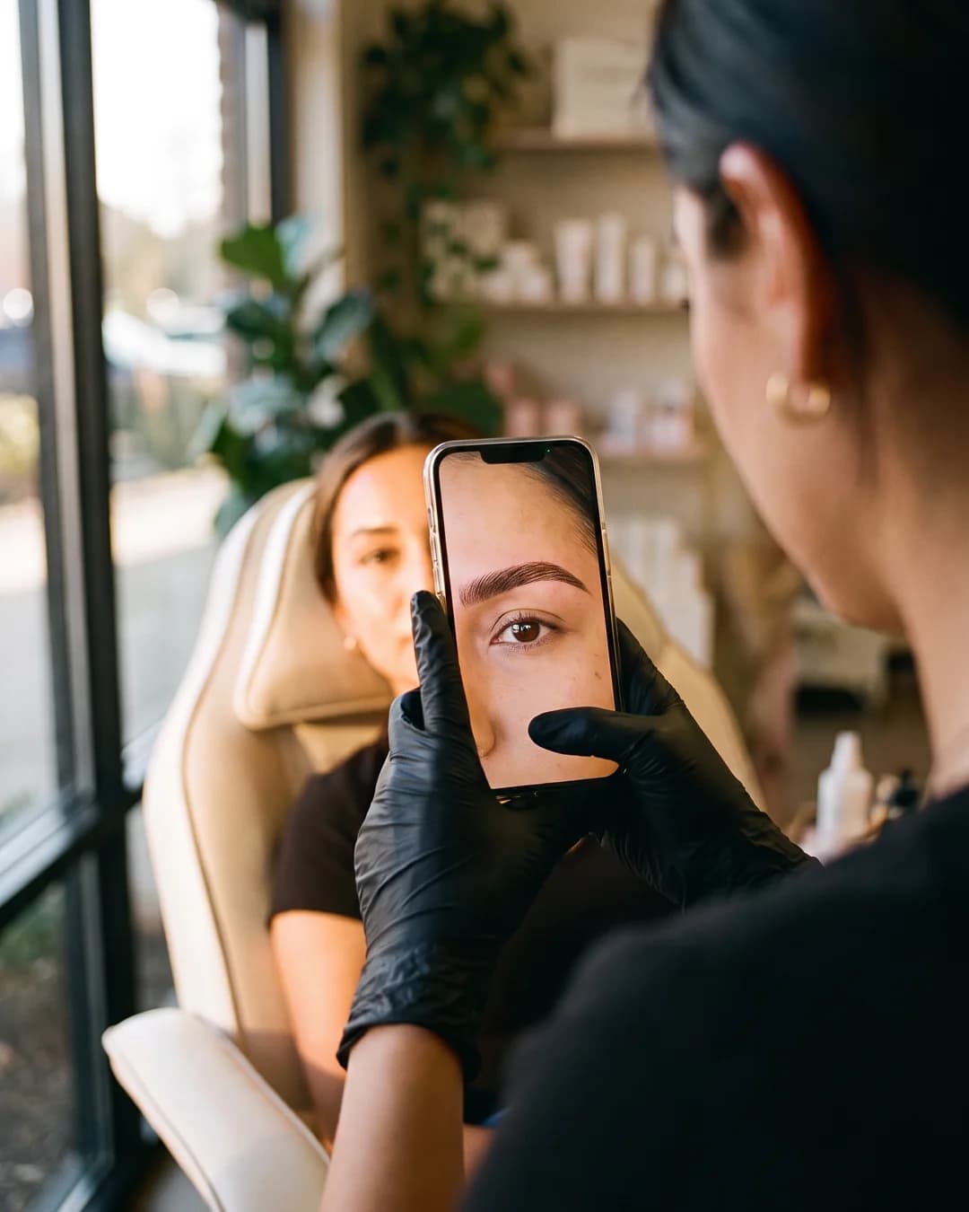 Telefono che fotografa il sopracciglio finito di una cliente.